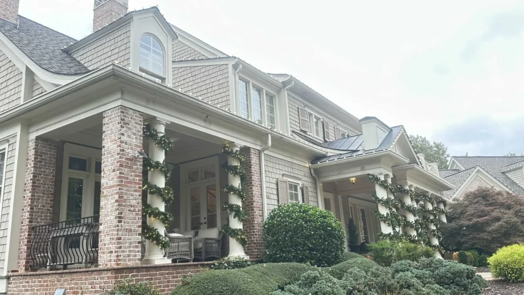 Daytime home exterior showing porch columns, rooflines, and landscaping suitable for Christmas light design